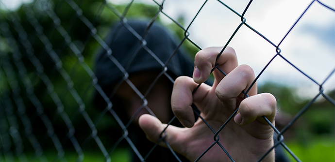 Young unidentifiable teenage boy holding the wired garden at the correctional institute