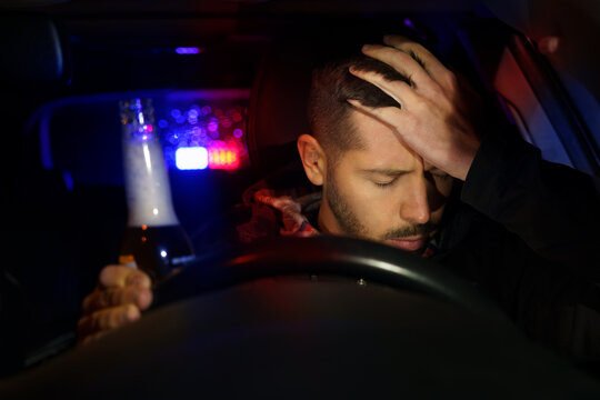 man holding beer getting pulled over