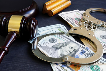 gavel, open handcuffs, and bail money on table