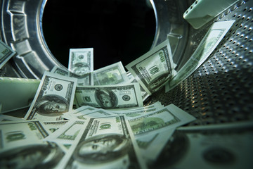 dollar bills in a washing machine to represent money laundering