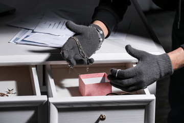 person's gloved hands committing larceny