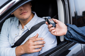 man and breathalyzer with police