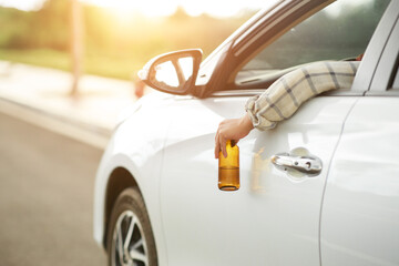 person in car with beer bottle