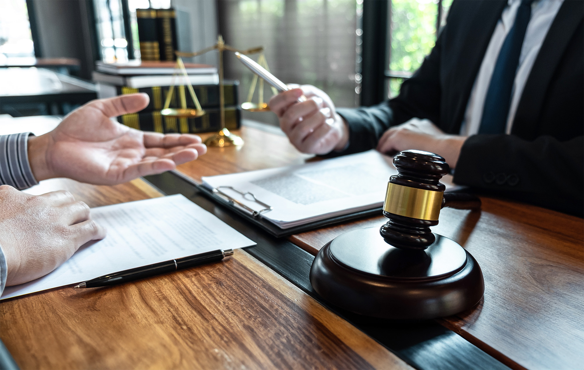Male lawyer discussing negotiation legal case with client meeting with document contact in courtroom