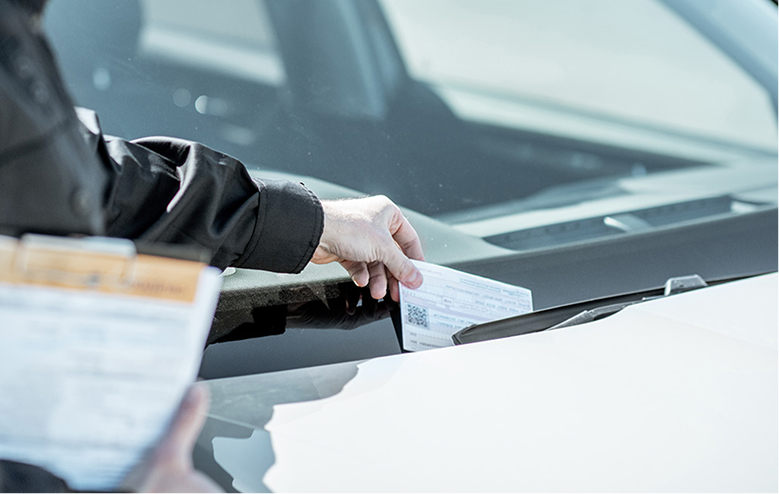 Traffic citation being left on car windshield