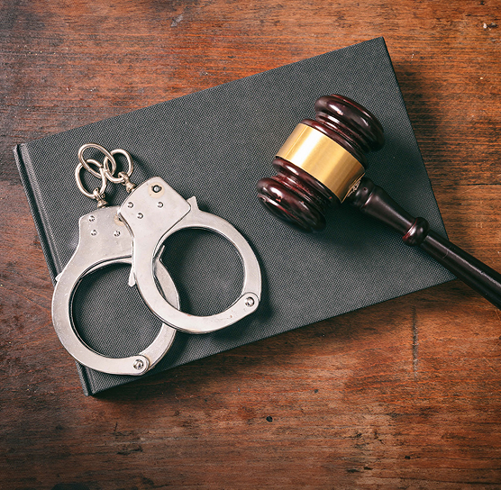 handcuffs, gavel, and book on a table