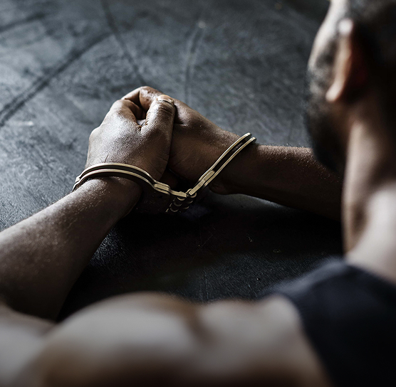 man in handcuffs sitting at a table