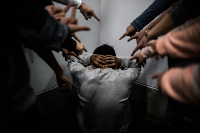 man with fingers pointed at him to indicate harassment